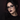 Adult alternative model wearing black prescription glasses with visible charcoal eye makeup, defined lashes and a muted blackberry lip