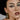 Close up portrait of a woman with dramatic smudged dark eye makeup and a black hat